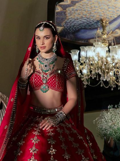 An environmental shot that adds a sense of luxury. Placing the model in a regal setting with a chandelier enhances the aspirational quality of the jewellery brand.