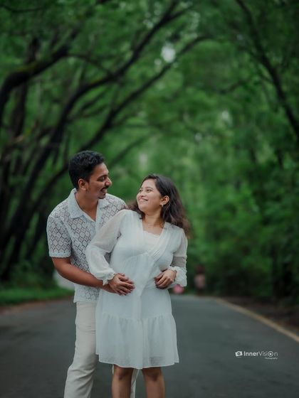 A candid moment of interaction and smiles on a beautiful green road. This photo captures the natural chemistry and happiness of the couple.