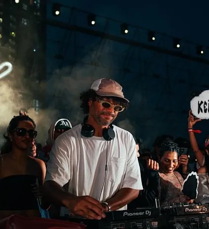 A fan holding up a "Keinemusik" sign at the &ME show, showing their love for the music collective. It's a community.