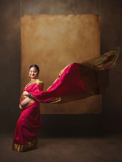 A traditional maternity photoshoot in a beautiful pink saree, showcasing the elegance and grace of the mother-to-be.