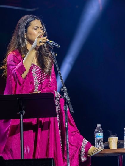Singer Priyanka Barve performing at the BMM show in the USA, styled in a beautiful fuscia pink ethnic ensemble.
