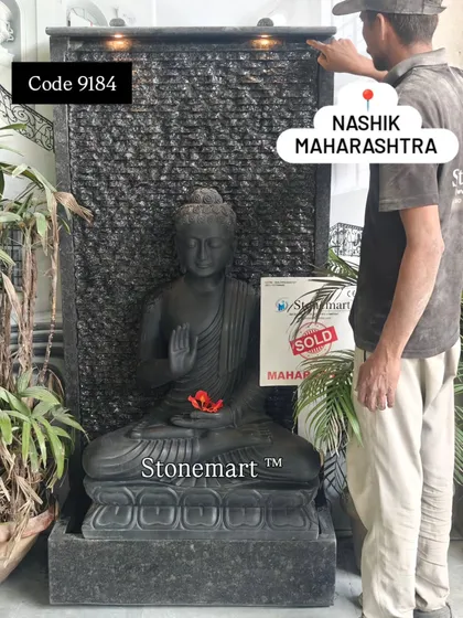 Our artisan stands next to the large Buddha fountain sold to Nashik, providing a sense of scale. This 5-foot piece features a 3-foot black marble Buddha and a ribbed granite waterfall.