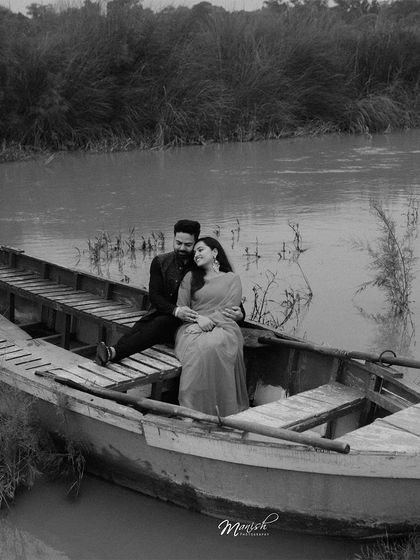 A timeless black and white portrait on a rustic boat. This shot from Tulsi and Mohit's pre-wedding session evokes a sense of classic, old-world romance.