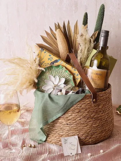 For a touch of countryside charm, the Rustic Delight Country hamper is perfect. It includes a bottle of wine, a diffuser set, chocolate barks, and hazelnut cookies.