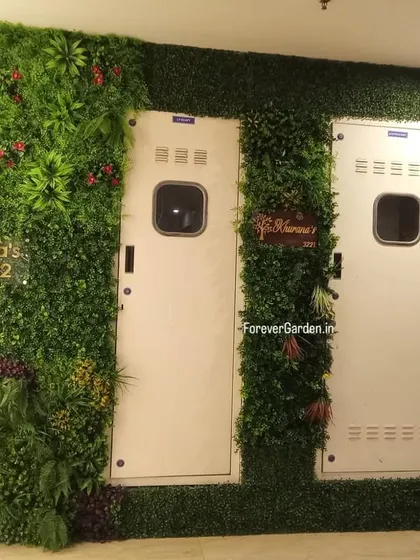 This creative installation uses artificial green wall panels to frame utility doors in an apartment lobby, turning a functional area into a design feature.
