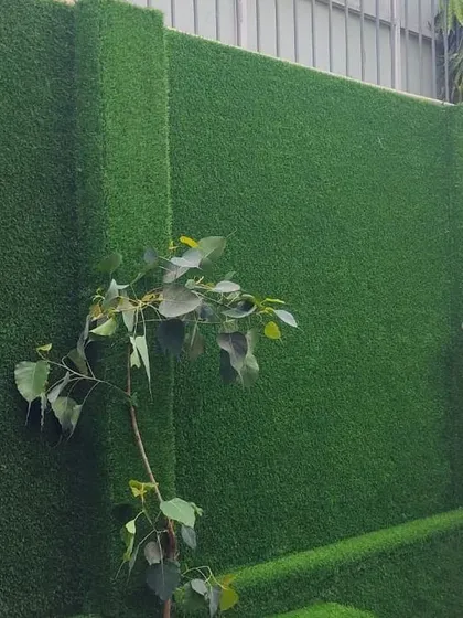 An artificial turf wall used to create a privacy screen. This is a practical and aesthetically pleasing solution to block out unwanted views and add greenery.