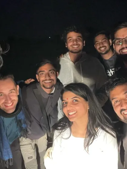 A happy group selfie around the bonfire. These are the faces of our travel tribe, full of joy and new friendships.