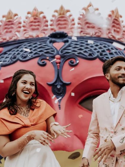 The couple enjoying a moment of celebration with confetti falling around them at their carnival party.