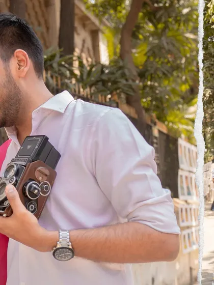 A detail shot from a Mumbai pre-wedding session, showing the groom holding a vintage camera. This adds a layer of storytelling and personality to the shoot.