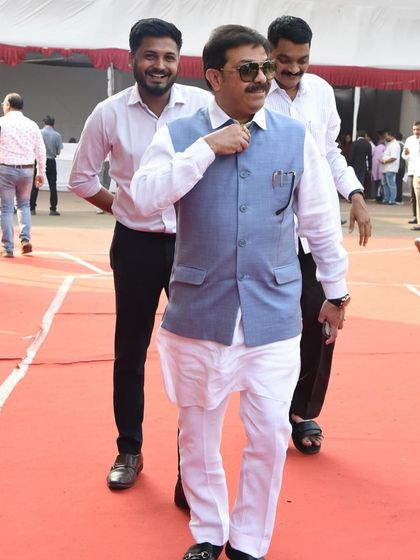 Prasad Lad looking confident on the red carpet in a classic white kurta and a light blue waistcoat. An elegant choice for a public appearance.