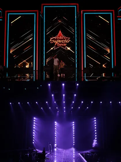 A before-and-after from the song 'Devi Aai' for the film 'Be Happy'. The bottom frame shows the clean, purple lighting on the empty stage, which provides the foundation for the final, multi-layered look seen on the LED screens.