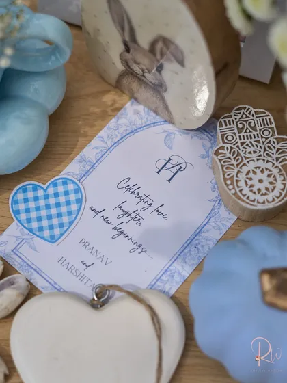 A close-up of the custom stationery and small decorative items, including a Hamsa hand block stamp and a heart-shaped tag.