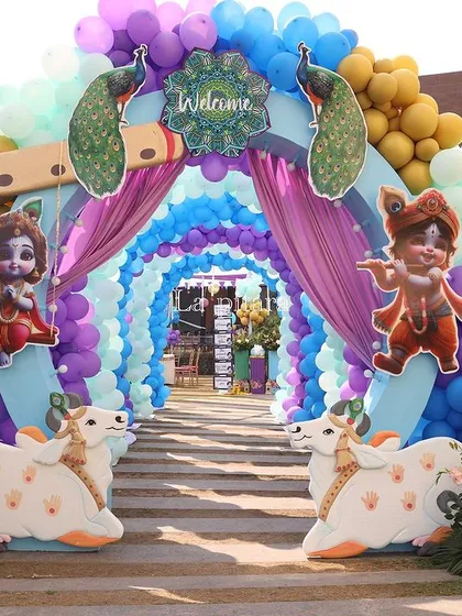 We created a joyful and vibrant entrance for a Krishna-themed baby welcome party. A tunnel of colorful balloons in shades of blue and purple, adorned with peacock and flute motifs, welcomed guests into a divine and playful celebration.
