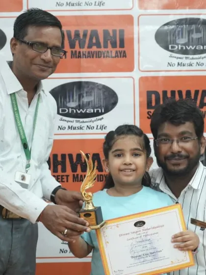 A teacher presents an award to a young girl for her beautiful painting.