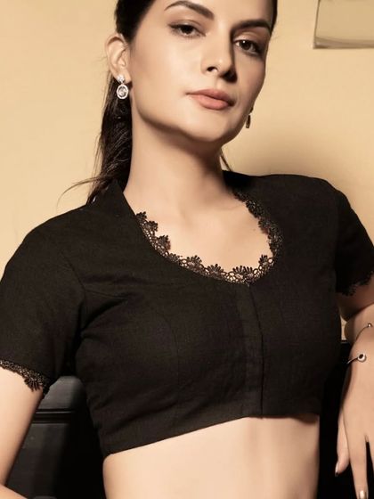 A full view of the black blouse with delicate lace trim. It's a versatile piece that can be dressed up for a party or styled for a more formal, elegant occasion.