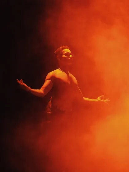 A moment from 'ATAH' where I am enveloped in orange smoke, creating a mystical and powerful visual.