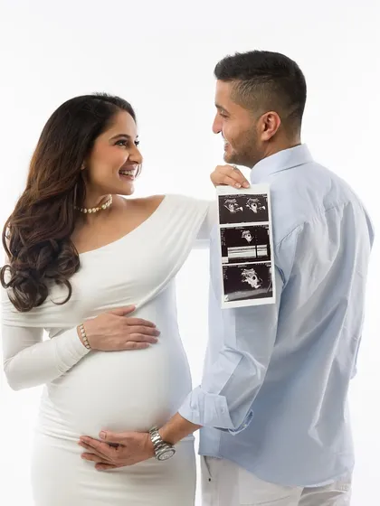 Incorporating your baby's first photos. This creative shot with the sonogram adds a deeply personal and meaningful touch to your couple's maternity portraits.