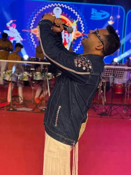 Singing my heart out on stage. The energy of the live band and the crowd is what fuels my performance as a Garba night host.