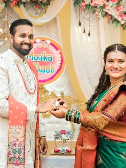 The couple proudly presents their engagement rings to the camera, a joyful shot celebrating their official union.