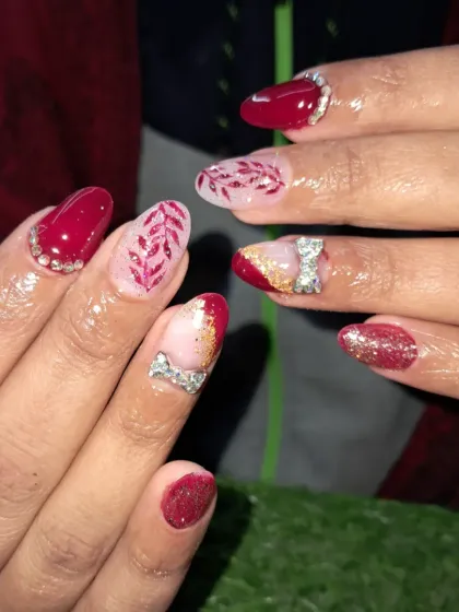 Another angle of this intricate red bridal nail extension set, showing the detail in the hand-painted leaves and the sparkle of the 3D bows.