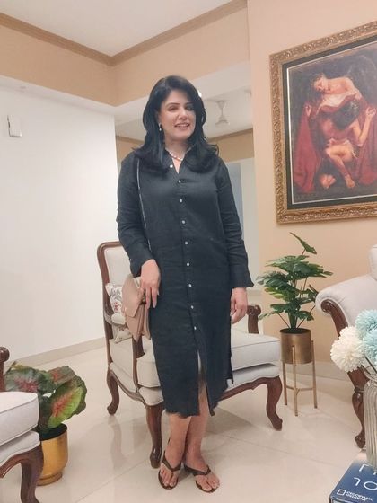 The full view of the black shirt dress. Its simple, classic silhouette makes it a versatile piece that can be dressed up or down for any occasion.