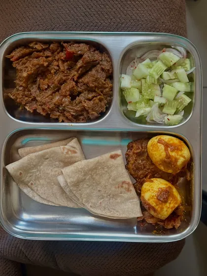 A simple meal of chapati, egg masala, tuna palya, and salad. This plate is high in protein and healthy fats from the eggs and tuna.
