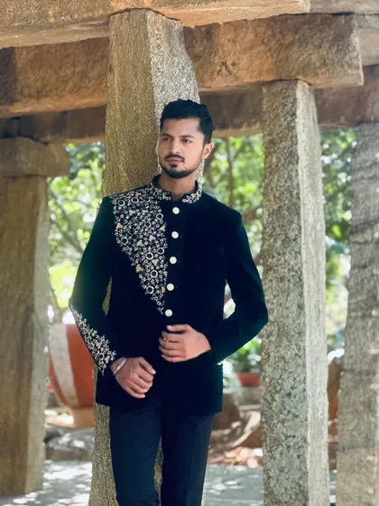 A full-length pose showcasing a dark velvet bandhgala, perfect for a winter wedding collection or formal event.