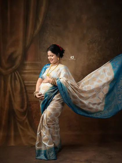 A graceful solo portrait of a mom-to-be in a flowing saree. The movement of the fabric adds a dynamic and artistic element to this traditional shot.