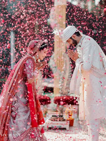 The couple exchanges a respectful 'Namaste' amidst a shower of petals, a beautiful moment of mutual reverence. We focus on capturing the cultural significance and emotion of each ritual.