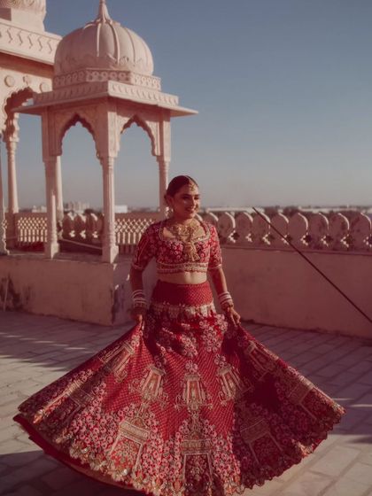 A joyful shot of the bride twirling, her red lehenga creating a beautiful circle of color and movement.