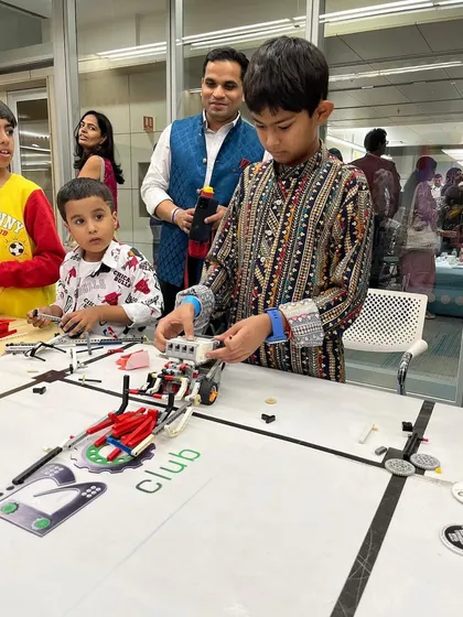 A father helps his son with a LEGO race car at a family event. My workshops provide a great opportunity for parents to get involved in their child's STEM learning journey.