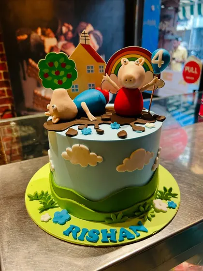 A playful Peppa Pig cake showing Peppa and George jumping in muddy puddles, perfect for a 4th birthday.