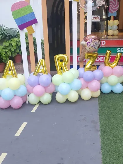 Personalization is key. Here, I've spelled out the birthday girl's name, "Aarzu," with large foil balloons integrated into colorful balloon stands.