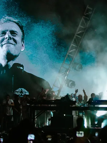 A cool shot of Armin van Buuren on stage with his image projected on the giant screen behind him.