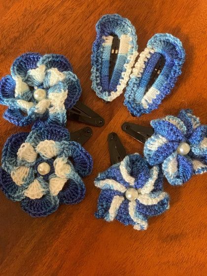 These beautiful hair clips are made with shades of blue and white yarn, creating a lovely floral design that is both elegant and playful.