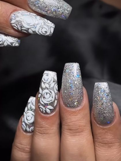 A stunning silver glitter set with intricate white rose art. This is a perfect look for a winter party or a glamorous bride.