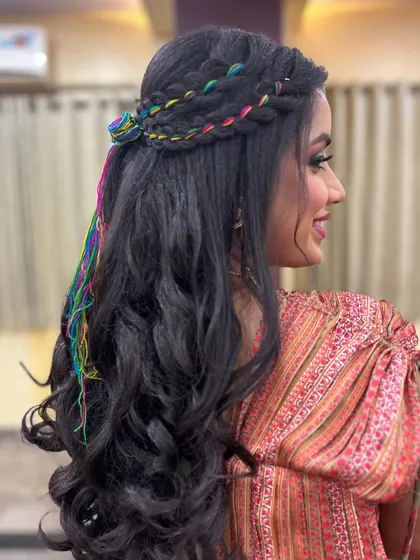 A side view of this creative Mehendi hairstyle. The crimped texture and colorful thread braids add so much personality to the look.