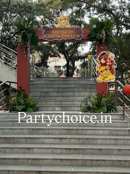 A wider view of the grand staircase entrance, flanked by life-sized cutouts of Mufasa and Pumbaa from The Lion King.