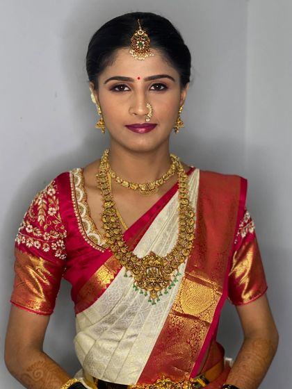 A direct portrait of Vathsala, showcasing the symmetry and precision of the makeup and jewellery placement, key to a polished bridal look.