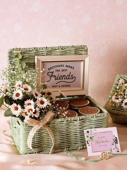 Wrap your love in elegance with our sage green Rakhi basket. It's filled with brownie bites, Sichuan crunch peanuts, Mexican trail mix, and chunk cookies.