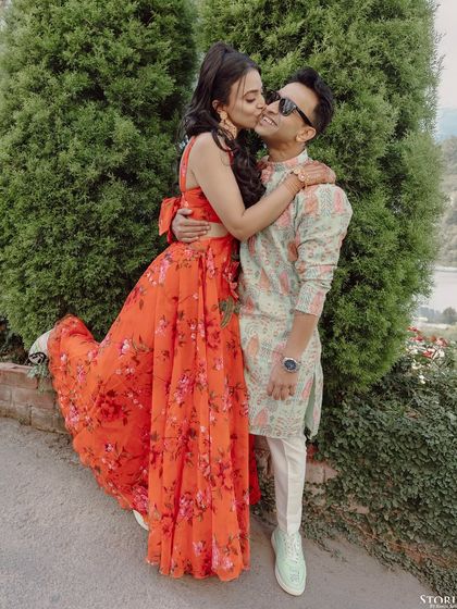 A sweet moment as the bride gives the groom a kiss on the cheek, full of genuine affection.