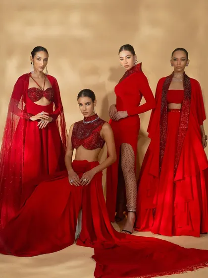 A powerful group shot showcasing four distinct outfits from Nikhil Thampi's 'Scarlet Edit'. The composition highlights the variety in silhouettes, all unified by the bold red color palette.
