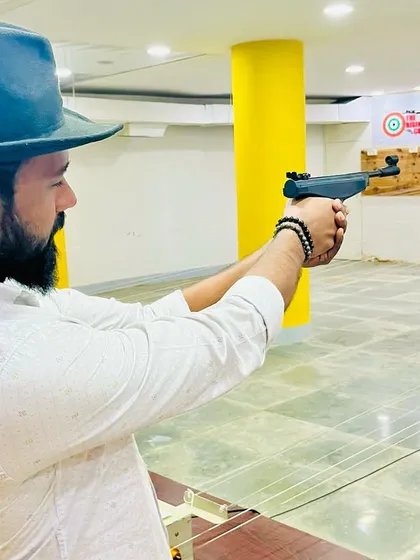 Focused and ready, a guest aims down the sights at our indoor shooting range. Notice the proper two-handed grip we teach for stability.