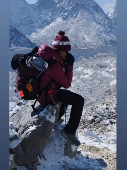 Pausing for a break with the Khumbu Glacier in the background. High-altitude trekking involves carrying gear, managing cold, and pushing through fatigue. We train for these specific conditions, ensuring your body is ready for the challenge.