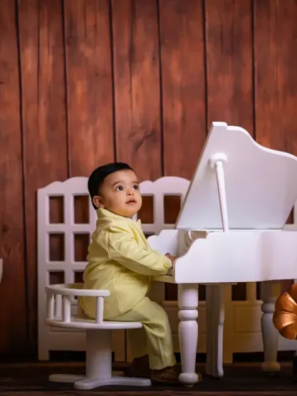 A handsome young performer in a yellow suit at his grand piano.