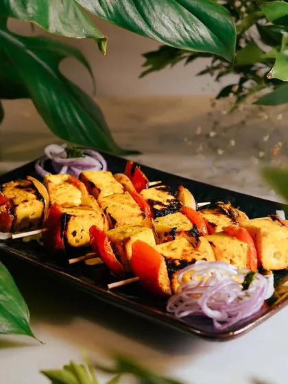 Another angle of the Saffron Paneer Skewers, showing the vibrant colors of the paneer, tomatoes, and onions. A visually stunning and delicious vegetarian option.