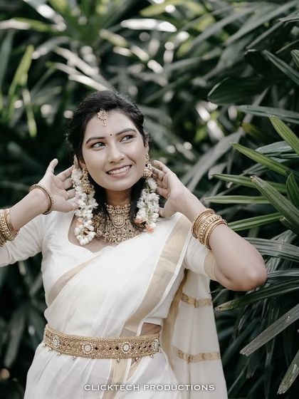 A playful and happy portrait of the bride-to-be in her traditional attire, adjusting her beautiful earrings.