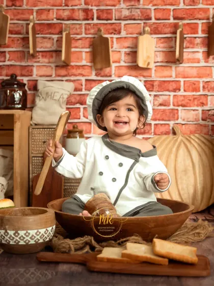 A creative "Little Chef" themed session, showing a baby's joyful expression in a chef's uniform. These imaginative shoots are a fun way to capture your child's budding personality.