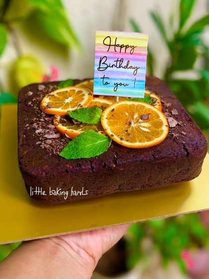 Holding up the rich dark chocolate and orange birthday cake to show its lovely presentation.