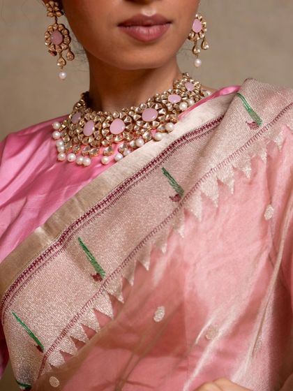 A close-up of the Paithani border, known for its intricate parrot and floral motifs woven with colorful silk threads.